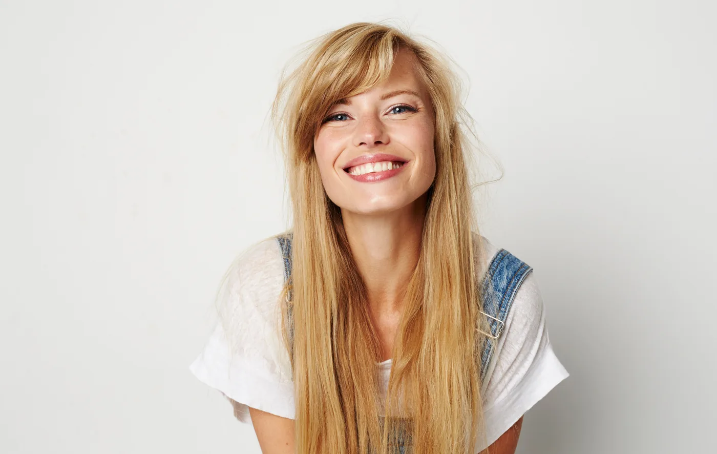 A smiling woman with long blonde hair, looking at the camera